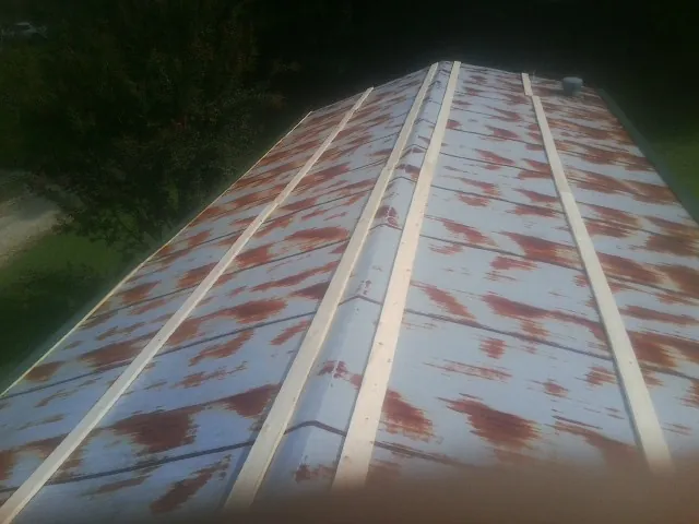 Rusted metal roof panels with new wood purlins before replacement in Louisville